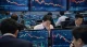 Stock traders on a busy trading floor surrounded by monitors filled with stock price charts and graphs.