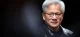 Portrait of an older man with gray hair and glasses in a black leather jacket, facing the camera. Studio portrait of a gray-haired man wearing glasses and a black leather jacket. Close portrait of an older man with glasses and silver hair, lit against a dark background. Portrait of a man in a black leather jacket, smiling slightly, with a dark blurred background.